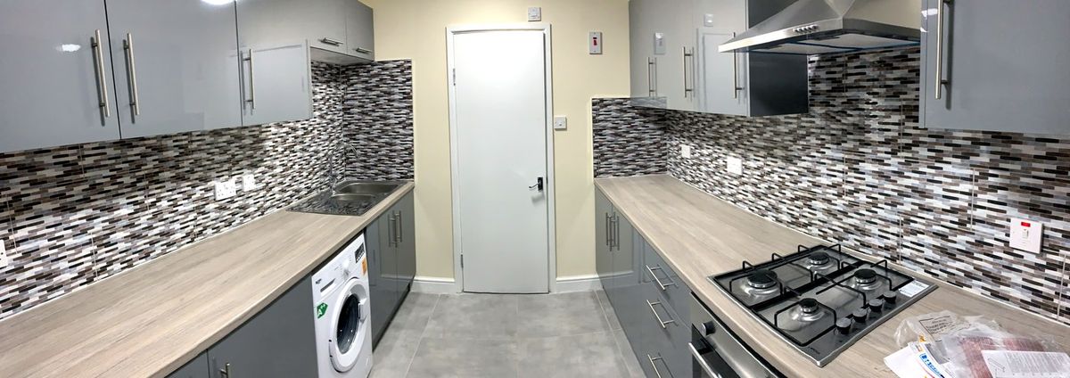 Galley kitchen renovation with mosaic splashback and grey gloss units